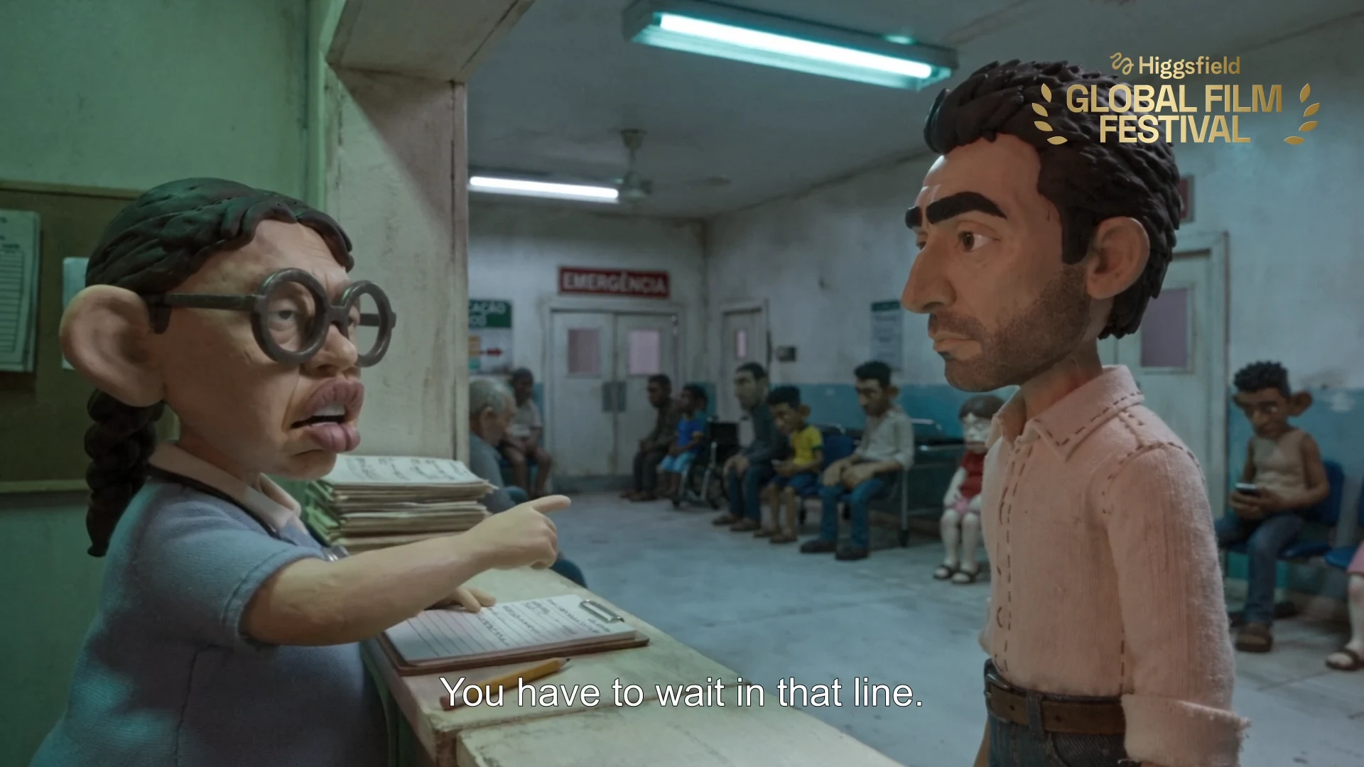 A hospital staff member addresses Isa's father across the reception counter while other people wait behind him, grounding the scene's communication barrier.
